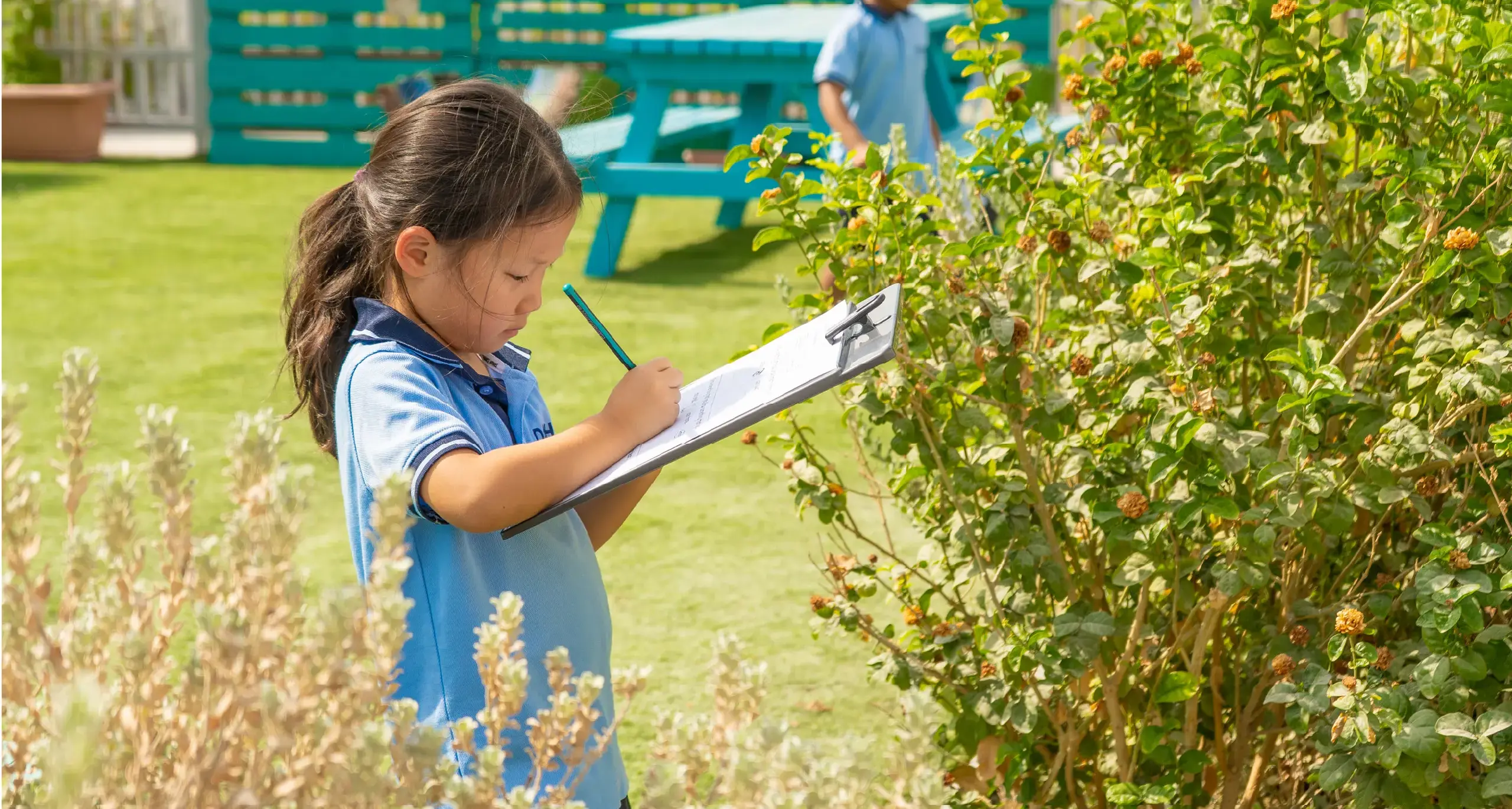 Student Studying Plants in Courtyard