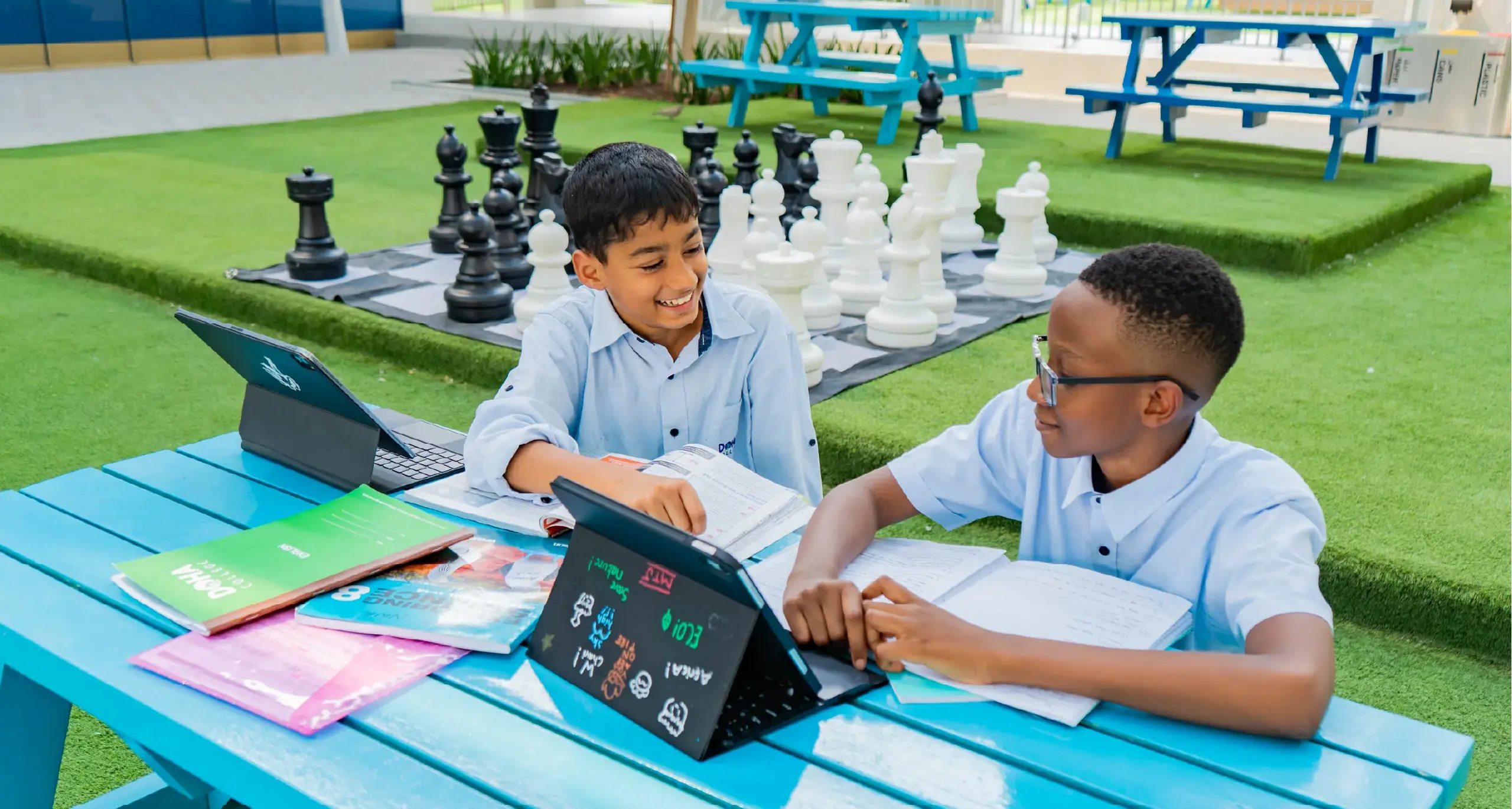 Two Young Male Students Studying on Laptops Together